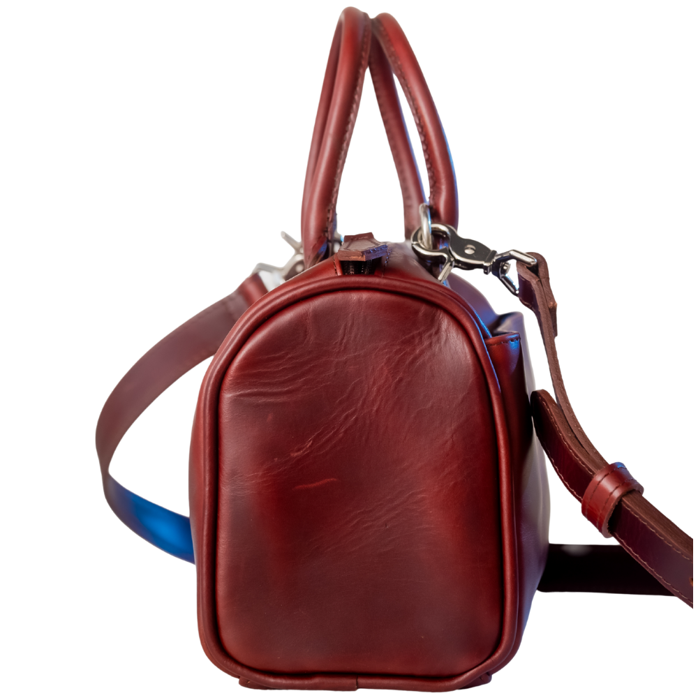The Bella bowling handbag purse from Miina Goods in burgundy leather on white background and showing a side view