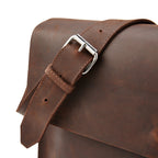 Close-up of Miina Goods Gabriel leather  messenger bag with a silver buckle on a white background