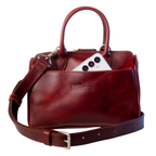 The Bella bowling handbag purse from Miina Goods in burgundy leather on white background and showing a phone in the front pocket.