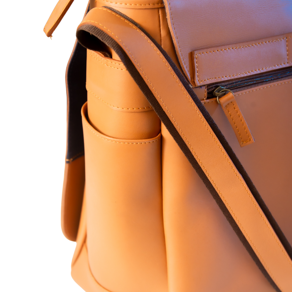 Close-up of El Unico leather travel bag from Miina Goods with a matching shoulder strap, front zip pocket, and side pocket on a white background.