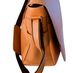 Close-up of El Unico leather travel bag from Miina Goods with a dark brown strap and silver-tone hardware, shown against a plain white background.