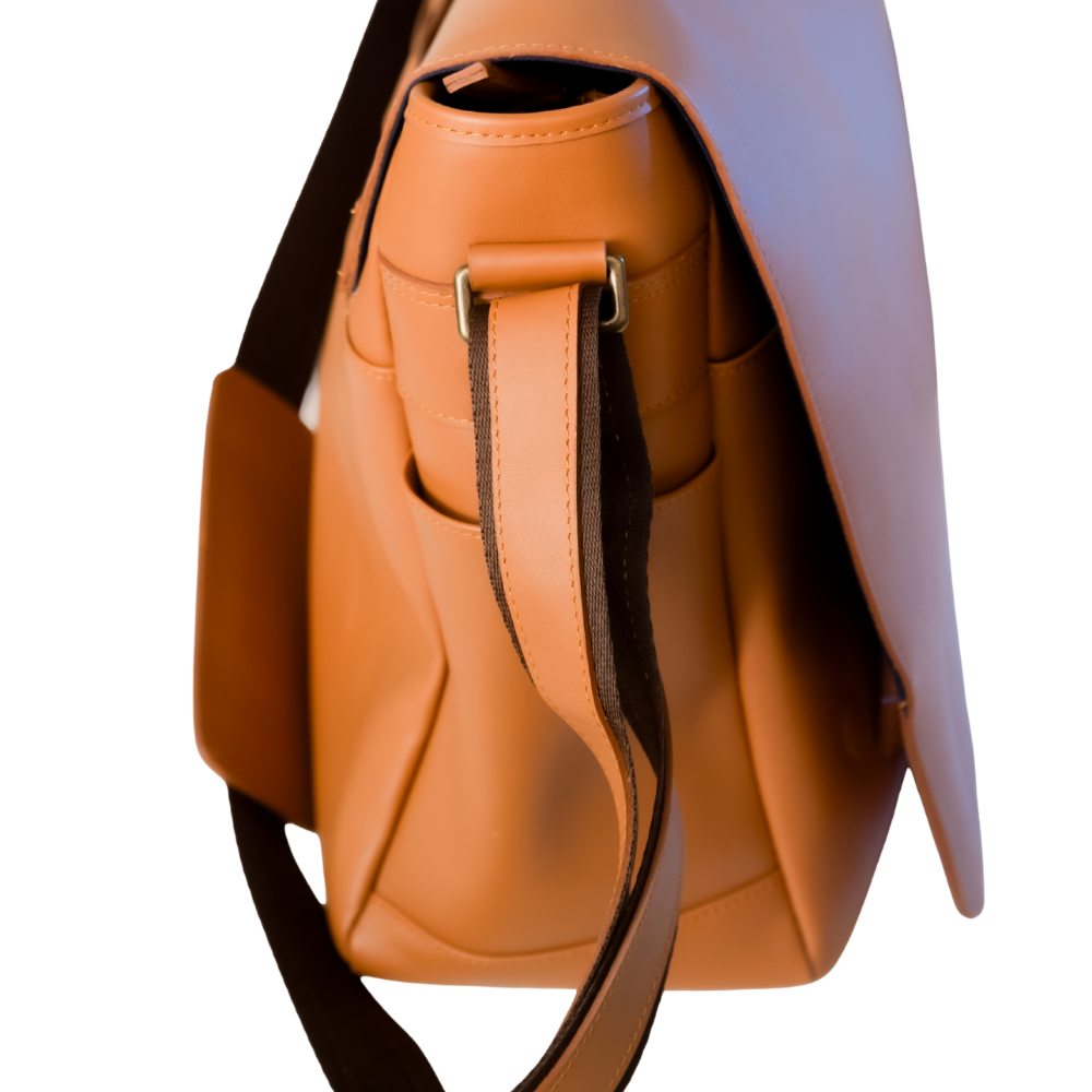 Close-up of El Unico leather travel bag from Miina Goods with a dark brown strap and silver-tone hardware, shown against a plain white background.