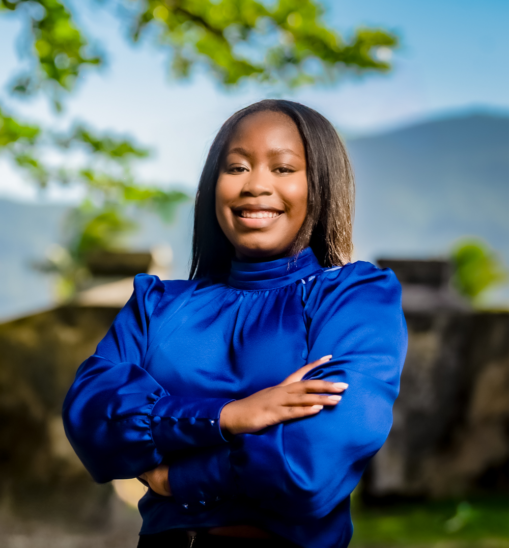 Widlene Earle, co-founder of Miina Goods standing in a blue blouse and smiling into the camera
