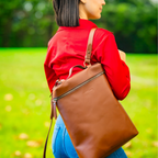 Miina Goods Leather Mochila backpack in cognac colour on model with one strap