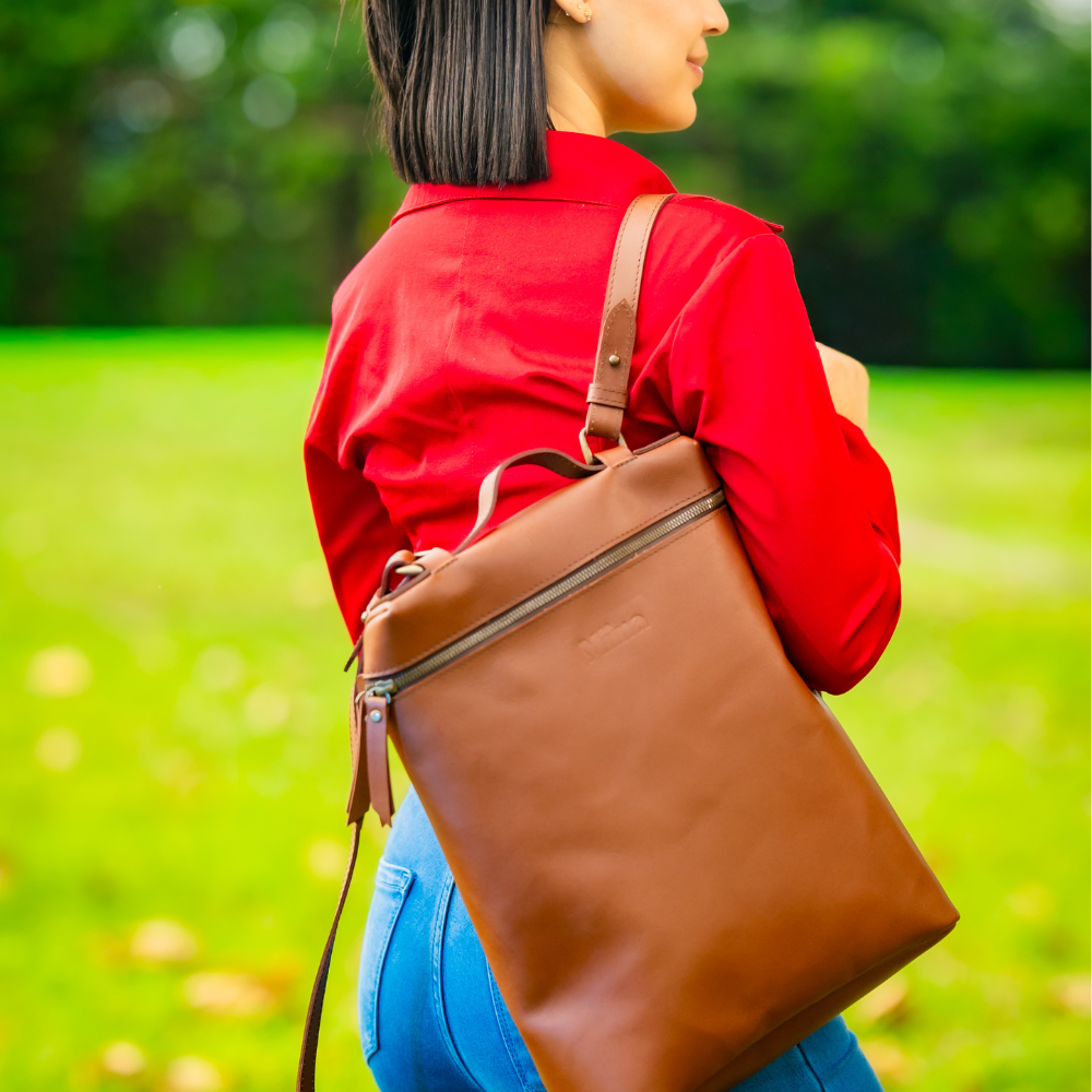 Miina Goods Leather Mochila backpack in cognac colour on model with one strap
