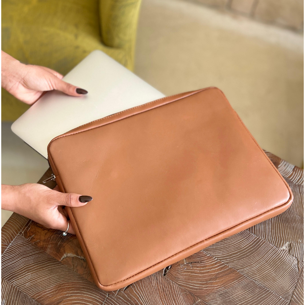 Simpatico laptop case in caramel leather from Miina Goods held by a hand.